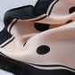 Beige silk scarf close-up with black dots and black curved stripe lines