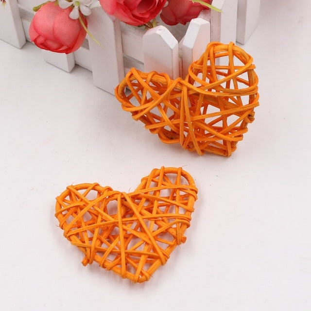 Orange rattan heart ornaments, two woven straw hearts with crisscross lattice pattern.