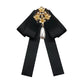 Black fabric bow with gold pearl and rhinestone floral brooch, dangling teardrop pearl
