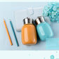 Mini vacuum flask bottles in a white case: orange and light blue with stainless caps.