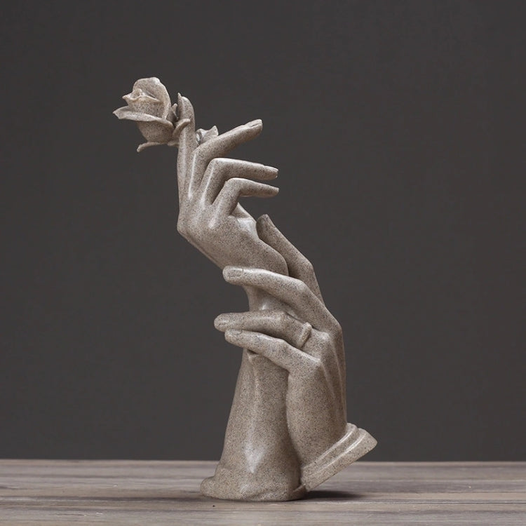 Abstract light-gray sculpted hands holding a small rose, upright decorative figurine.