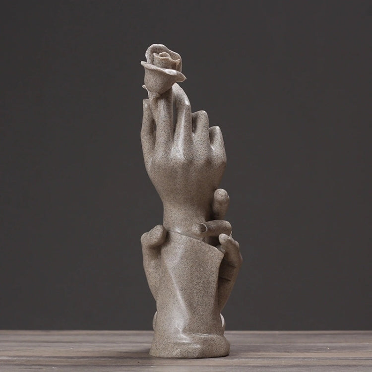 Abstract light-gray sculpted hands with a raised flower, standing decorative figurine.