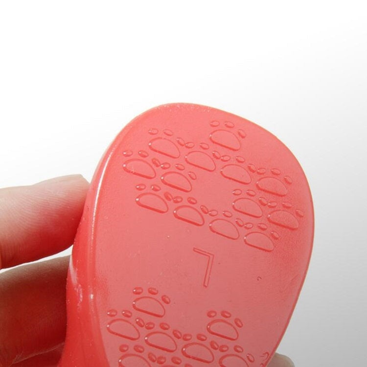 Close-up of red non-slip dog boot sole with paw-print traction pattern