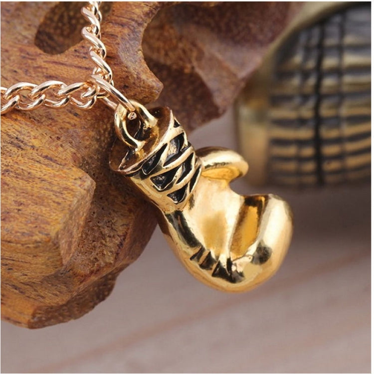 Gold boxing glove pendant necklace, close-up of charm on chain
