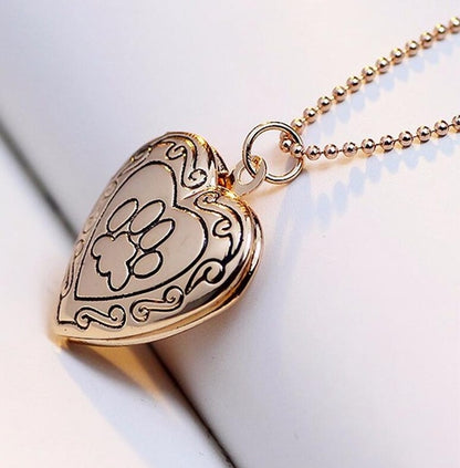Gold-tone heart locket pendant necklace with paw-print photo frame front