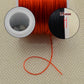 Red elastic cord on spool with 1.5mm size indicator
