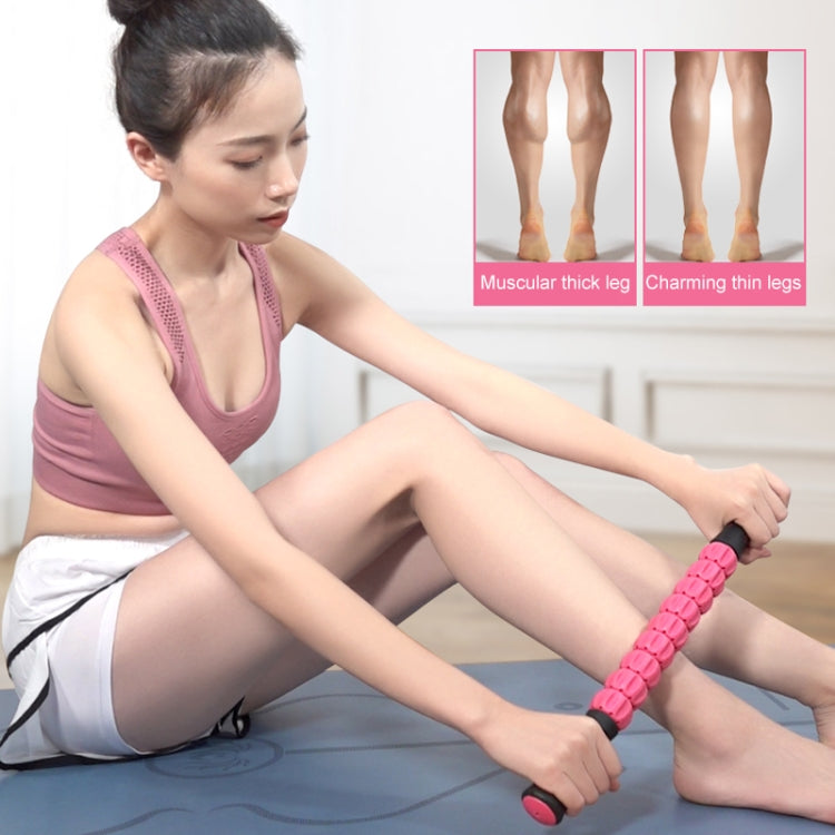 Pink segmented body massage roller stick used under leg for self-massage.