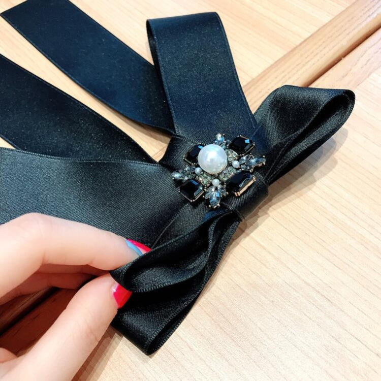 Black satin bow brooch with oval pearl and rhinestone cluster center, pin clasp.