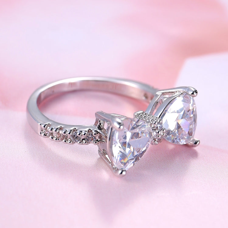 Silver bowknot zircon ring with three clear marquise stones on a light background