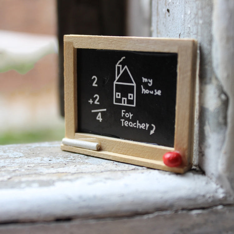 Miniature wooden blackboard with chalk math and house drawing, red knob on frame