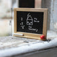 Miniature wooden blackboard with chalk math and house drawing, red knob on wooden frame