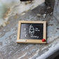 Miniature wooden blackboard with chalk math and “For Teacher?” text, red knob