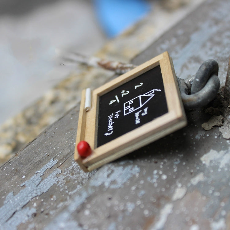 Miniature wooden blackboard with chalk house sketch and arrow marks, red knob on frame