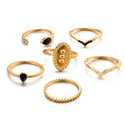 Gold-tone waterdrop ring set, six stacked bands with black stones and clear accents