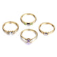 Four gold-tone crystal rings with green and purple stones plus clear center and pave details