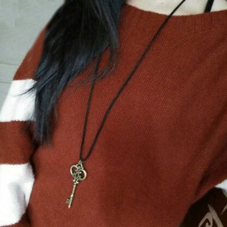 Model wearing crown key pendant necklace with dangling key charm on cord