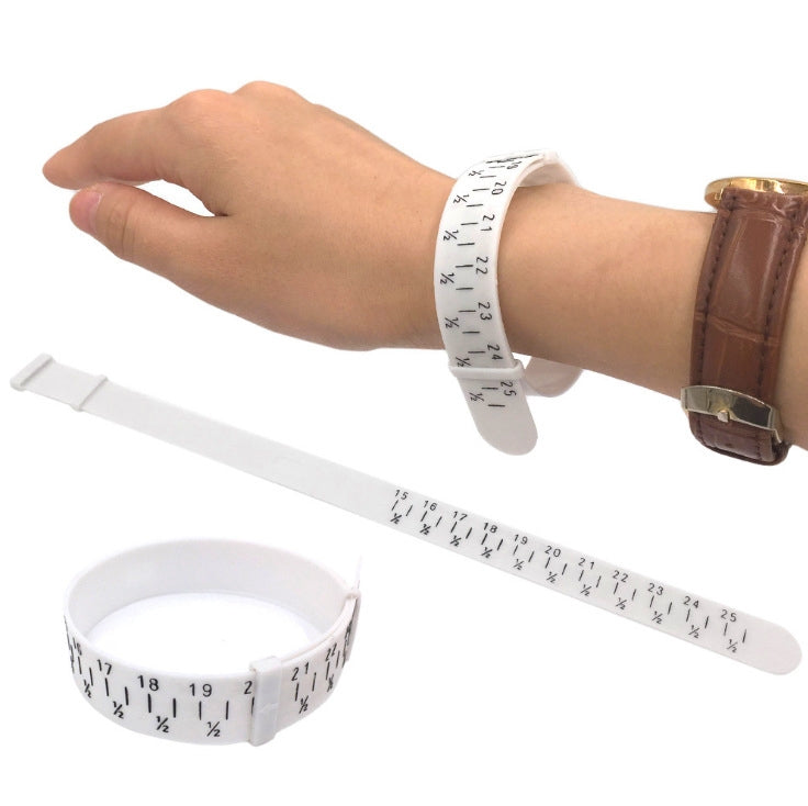 White wrist measuring bracelet gauge on a hand with ruler strip for jewelry sizing