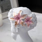 White resin bust statue head with pink and gold floral crown detail