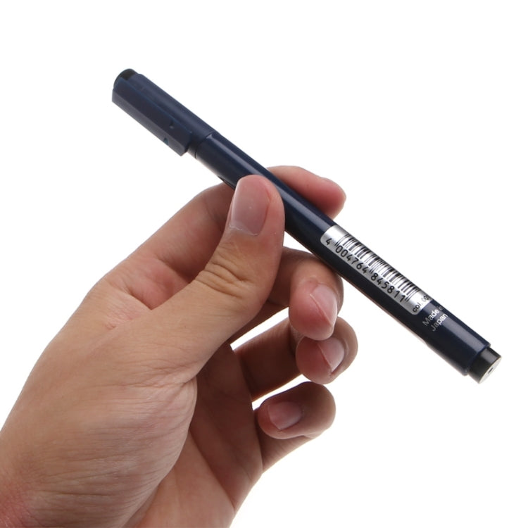 Engraver pen held in hand, showing dark barrel and fine engraving point
