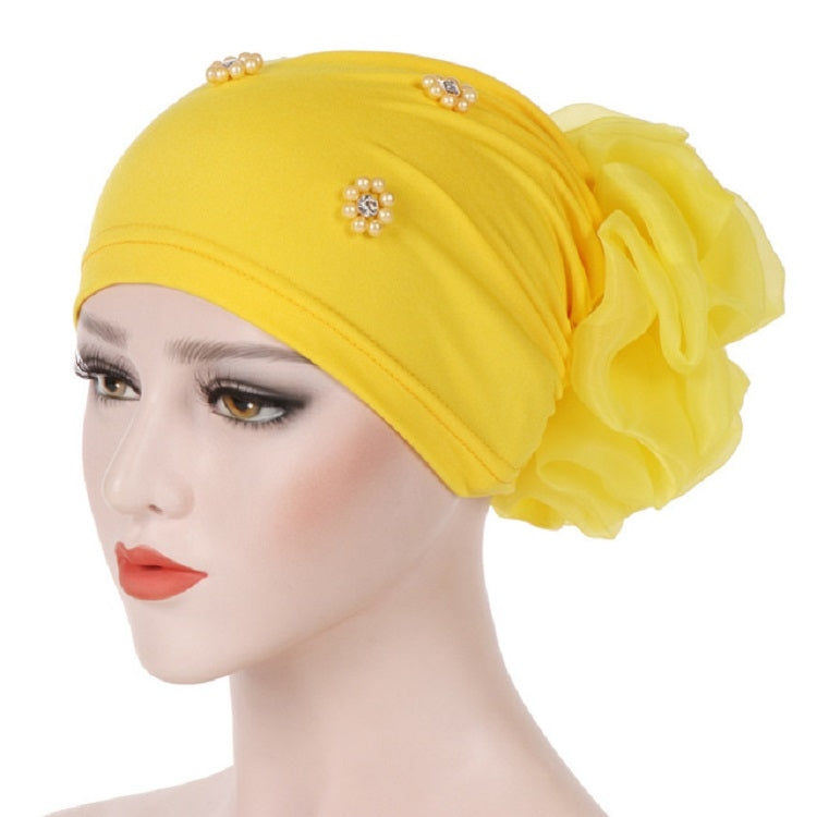 Beaded yellow turban hat with rosette flower detail and pearl-like embellishments