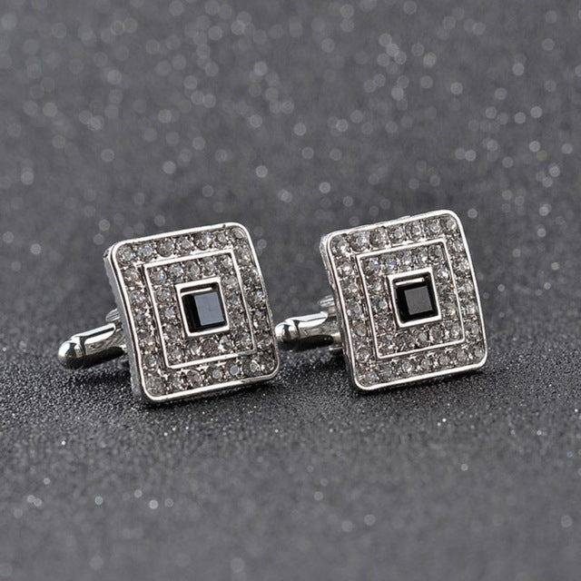Silver-tone square cufflinks pair with black center and glittering rhinestone border