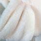 White plush faux rabbit fur scarf close-up, soft fluffy shag texture.