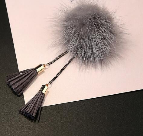 Gray fur ball chain tassel brooch with black tassels and gold connector bars