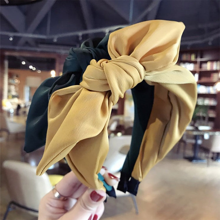 Beige fabric rabbit-ear bow headband with oversized knotted bow and ear tips