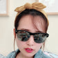 Beige rabbit-ear bow headband with large knotted bow, front-worn on hair