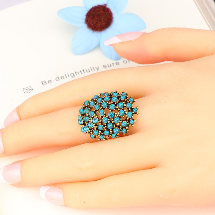 Blue rhinestone cluster ring on finger, gold-tone setting, size 7 close-up