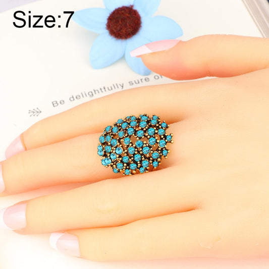 Blue rhinestone cluster ring on hand, gold-tone setting, size 7