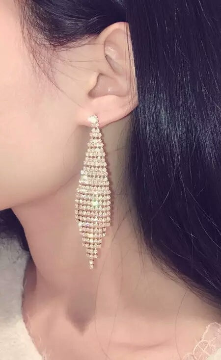 Gold rhinestone tassel clip earrings, long dangling tiered design worn on ear