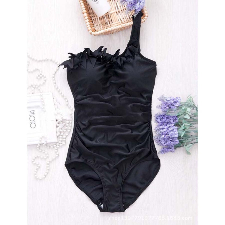 Black one-piece swimsuit with one-shoulder ruffled neckline, flat lay on white background