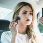 Makeup brush in use, soft black bristles on a black handle for applying face makeup
