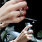 Silver zircon wedding ring on finger with square-like setting and round center stone