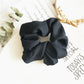 Black fabric scrunchie hair tie with large ruffled loop, seamless stretch design