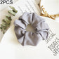 Gray fabric scrunchie hair tie with large ruffled swirl for seamless ponytail hold