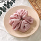 Light pink fabric scrunchie hair tie with large gathered ruffle loop for ponytail