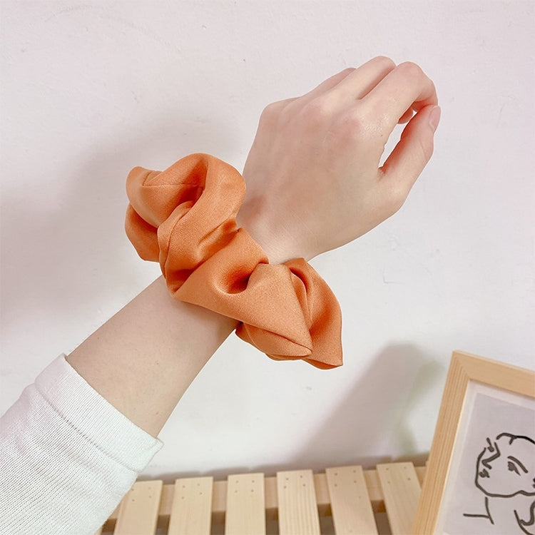 Orange fabric scrunchie hair tie on wrist, large gathered ruffle loop for ponytail