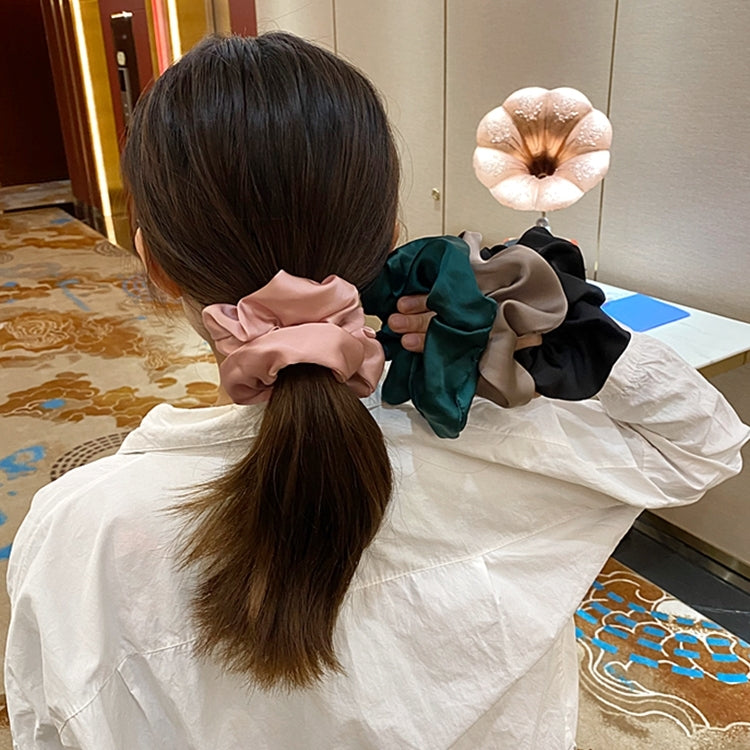 Mixed-color fabric scrunchie hair ties holding a low ponytail, back view