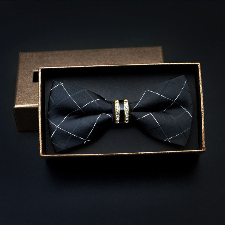 Men's dark patterned bow tie with metal bar rings at center, shown in box