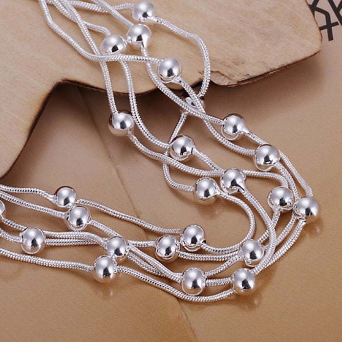 Silver plated multi-strand bracelet with dangling round bead charms and knot-style links