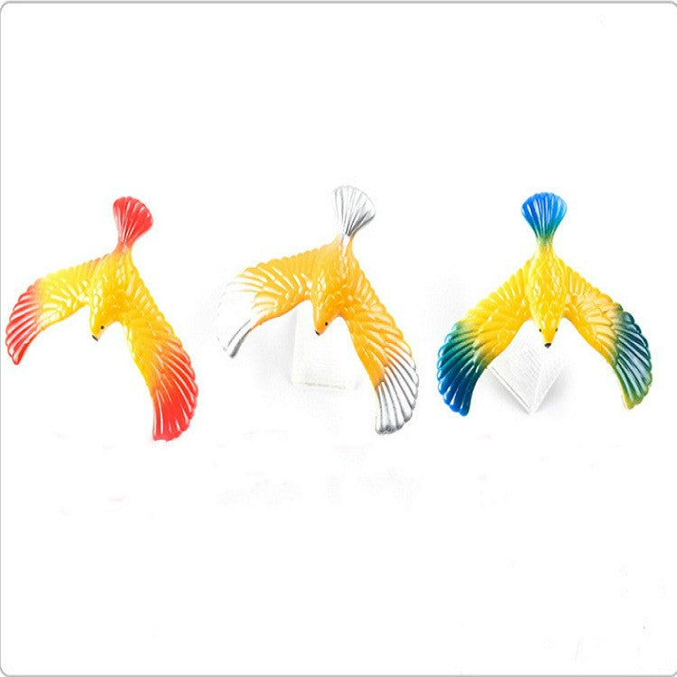 Set of colorful eagle balance bird toys with white triangular bases (red, yellow, blue)