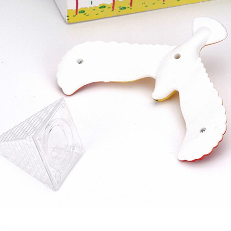 White eagle balance bird toy with clear triangular base on flat surface