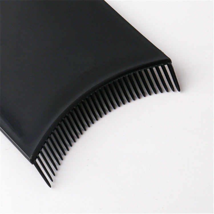 Black comb-style hair dye applicator brush, close-up of fine teeth