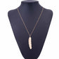 Gold long feather pendant necklace on mannequin