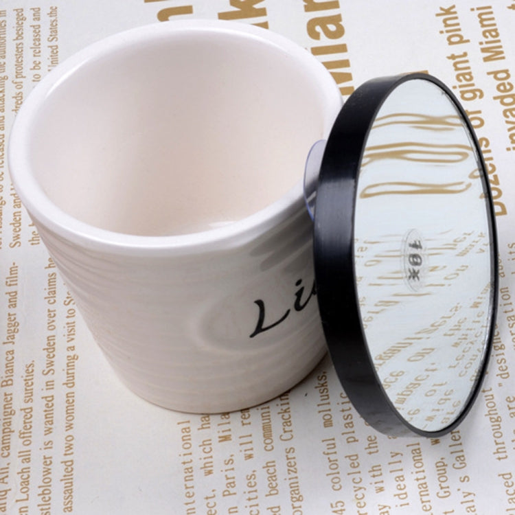 Black round magnifying mirror with reflective lens and thick outer rim