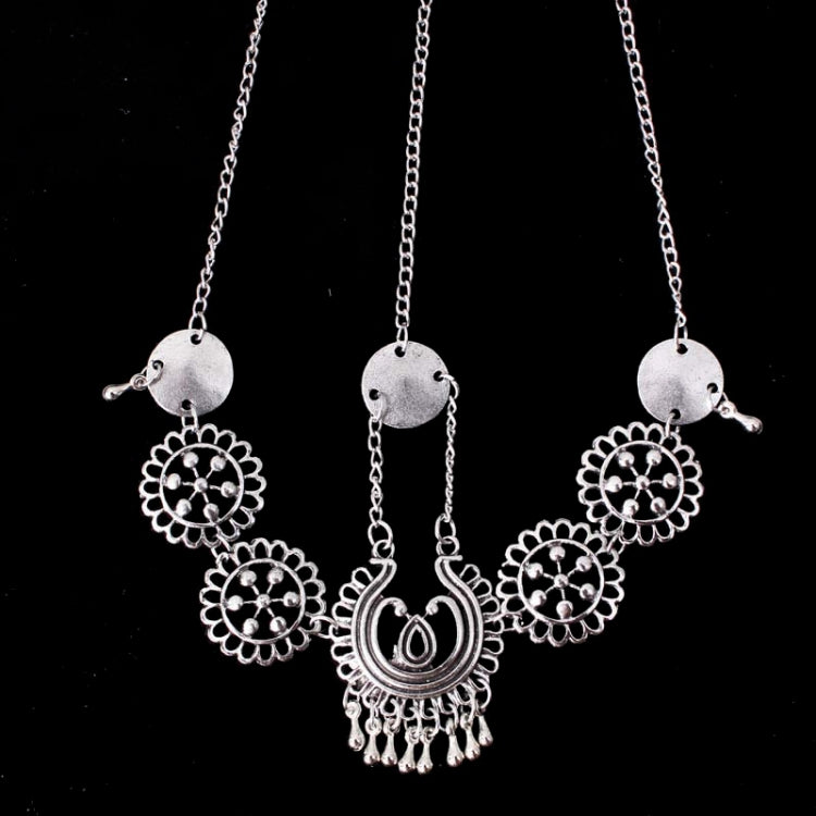 Silver coin head chain with three long strands, round floral medallions, and central crescent charm