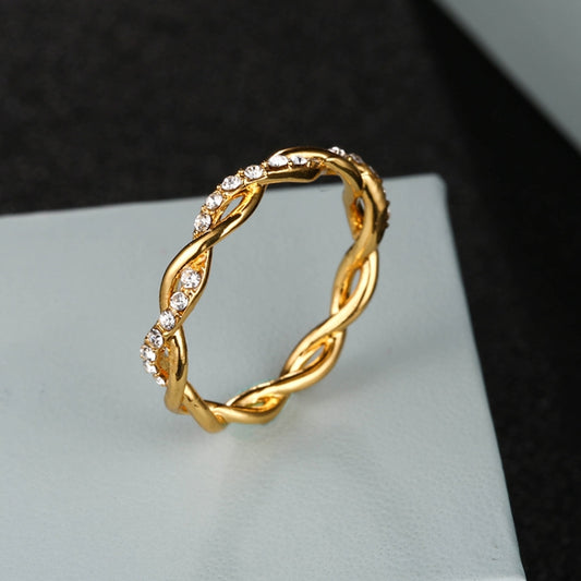 Angled view of a gold-tone twisted ring set with clear stones