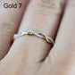 Twist-style cubic zirconia ring on finger, gold-toned metal with small round stones.